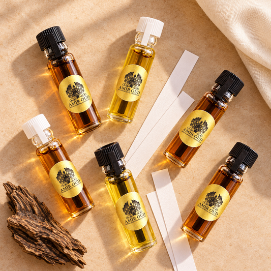 Amir Oud Premium oil sample vials photographed from above with oud wood and scent strips